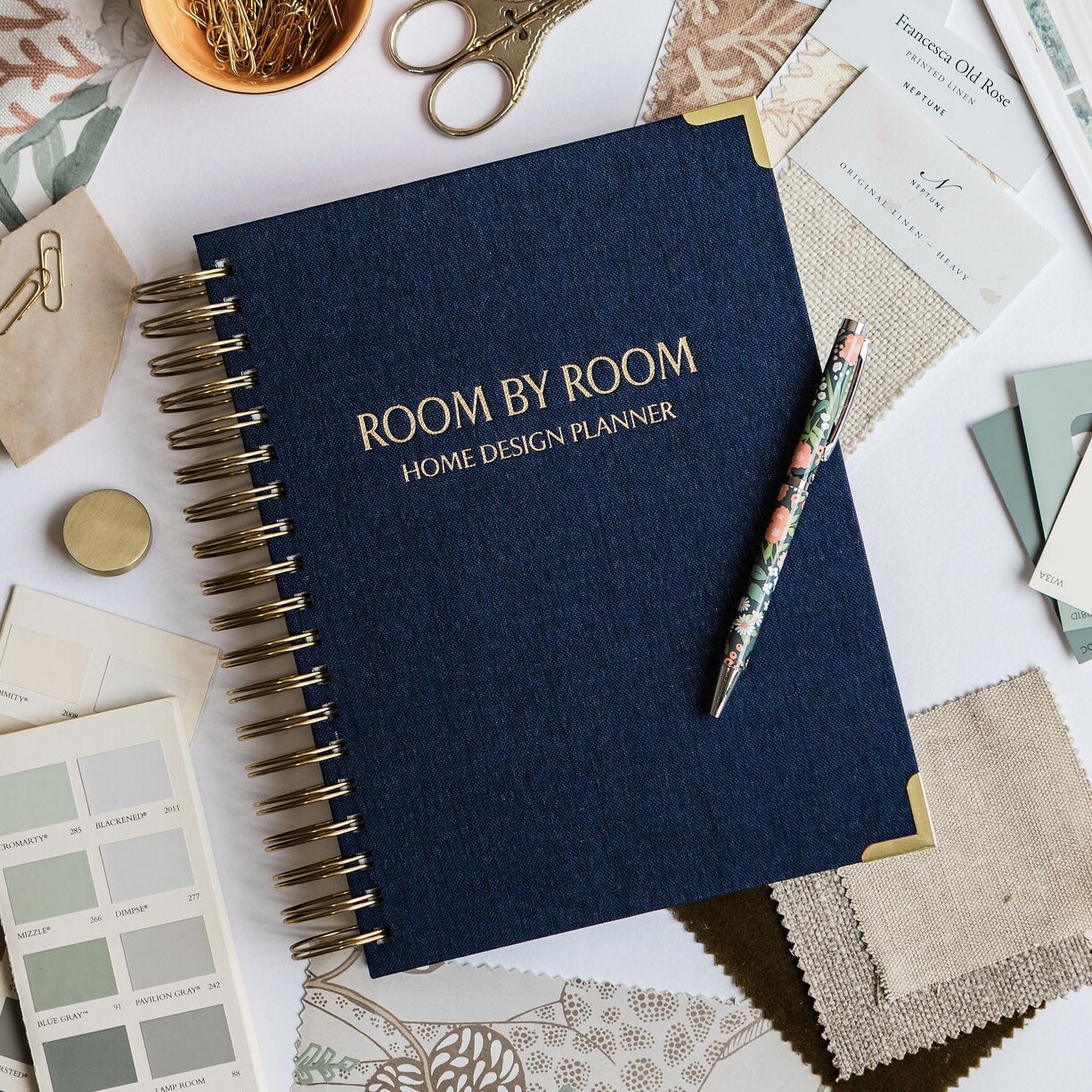 neutral cover of room by room planner with pen and samples.